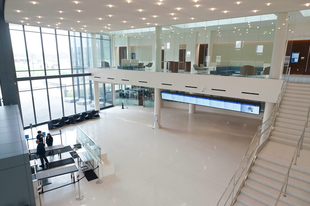 Overview image of the Johnson County Courthouse with the security check in on the bottom left near the glass door entrance and the upstairs hallway showing in the top of the image.