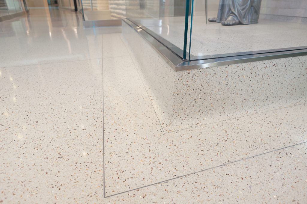 Close up image of a glossy white speckled floor on the corner of the wall.