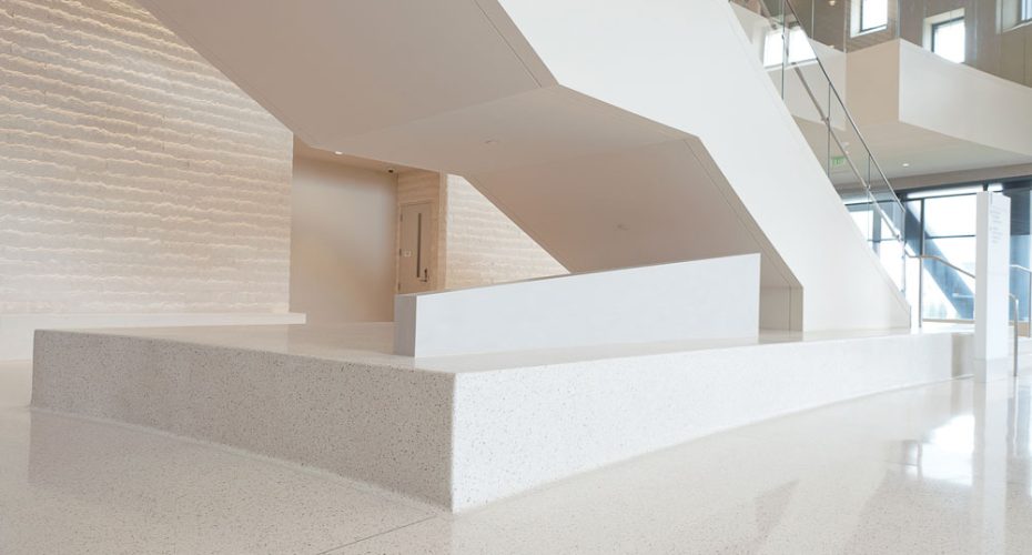 Entryway staircase displays the marble monochromatic terrazzo flooring.